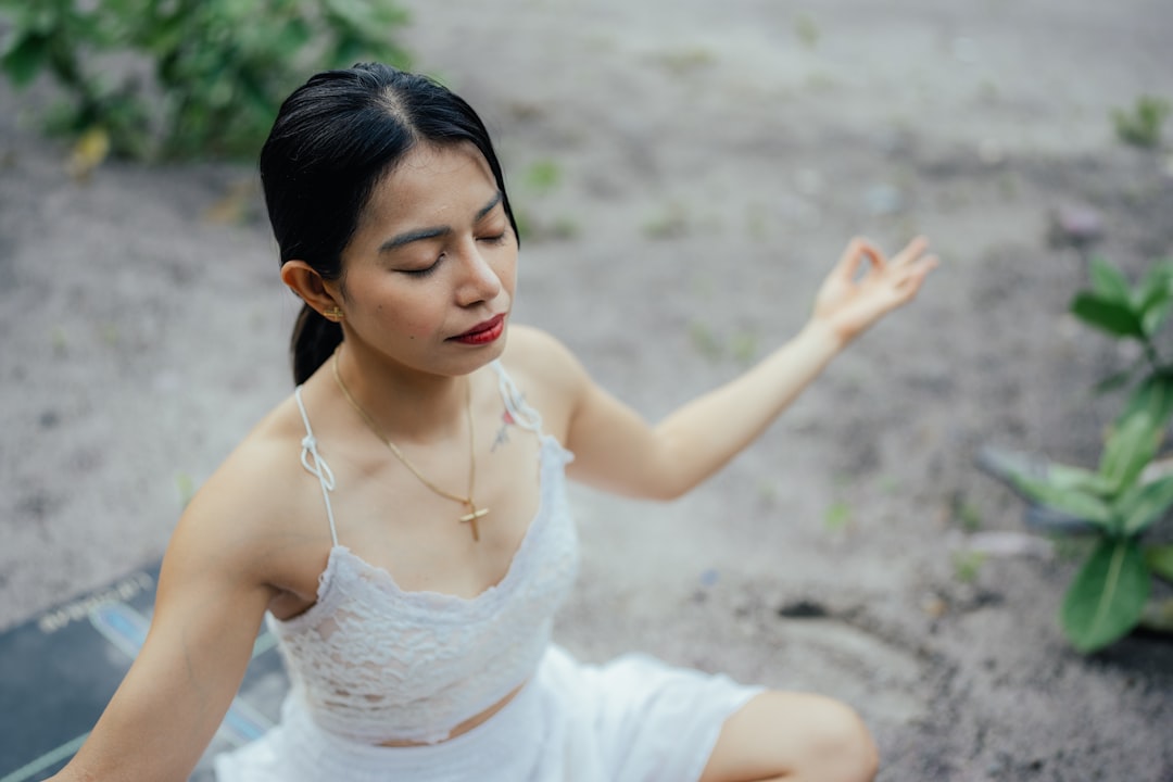 a-woman-in-a-white-dress-sitting-on-the-ground-wedslw0so8g