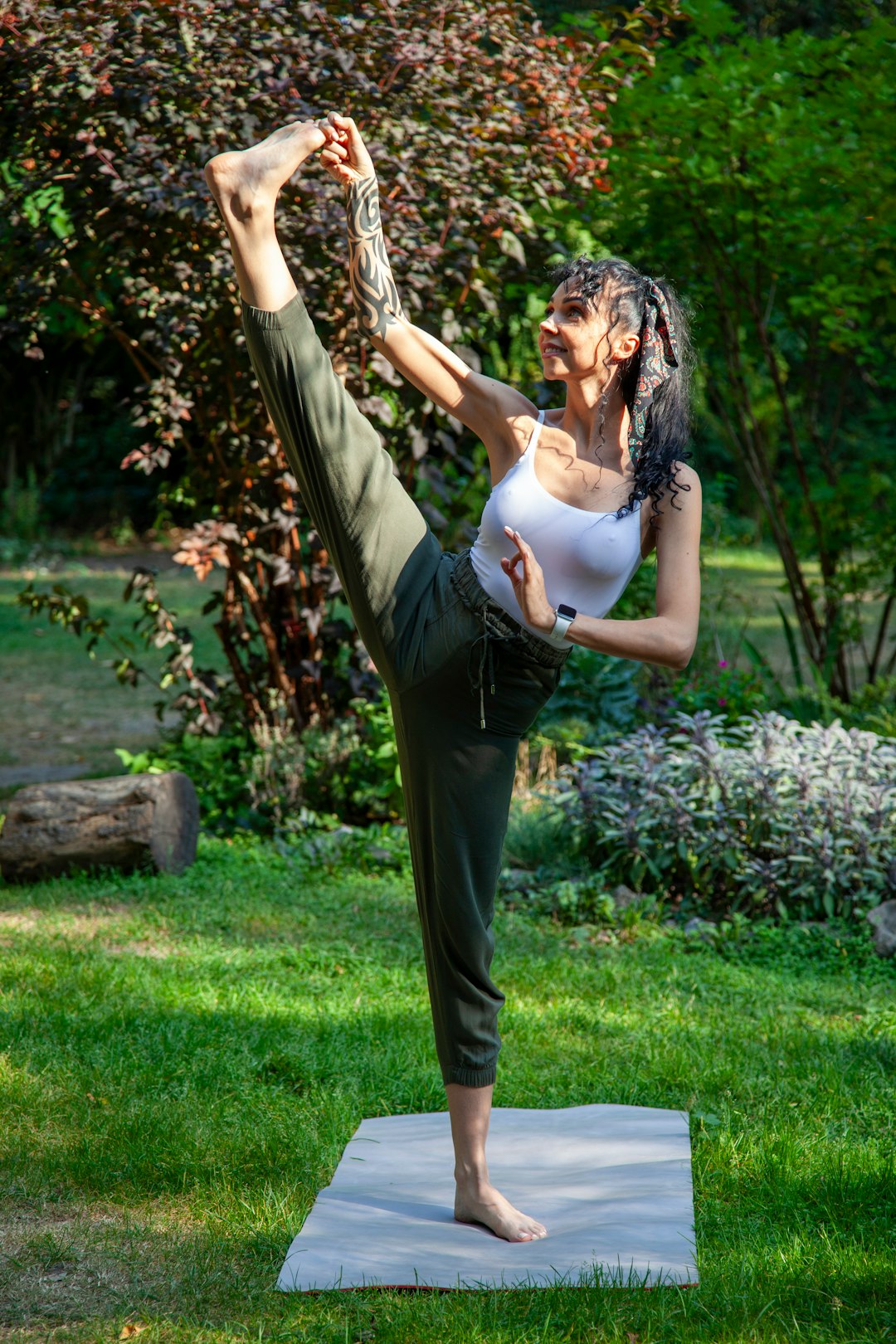 a-woman-doing-a-yoga-pose-in-a-park-jbpn5-4kfo4